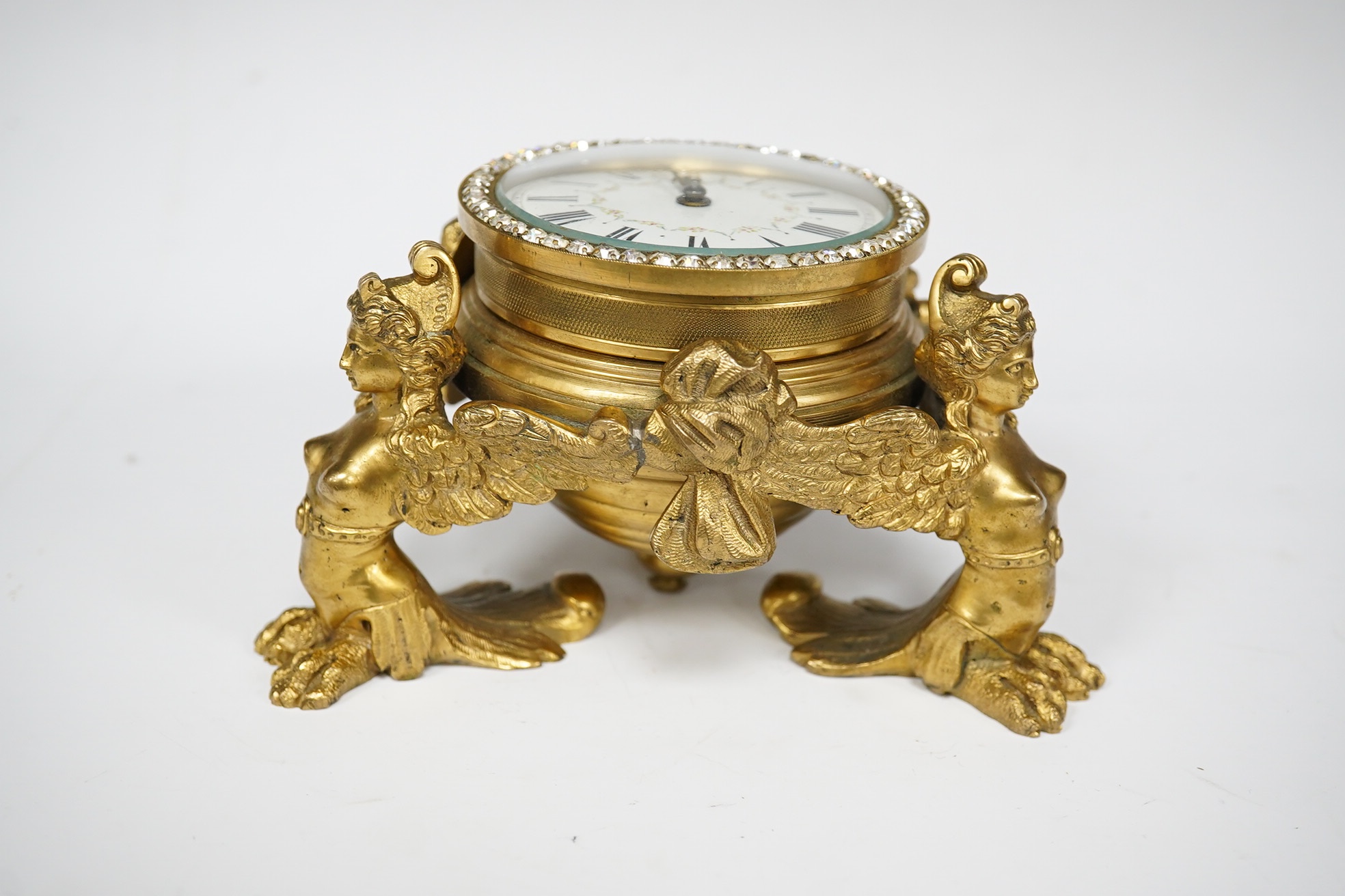 A 19th century French ormolu table timepiece decorated with paste jewelling edged dial and three classical figures, widest point 15cm. Condition - good, not been checked as working